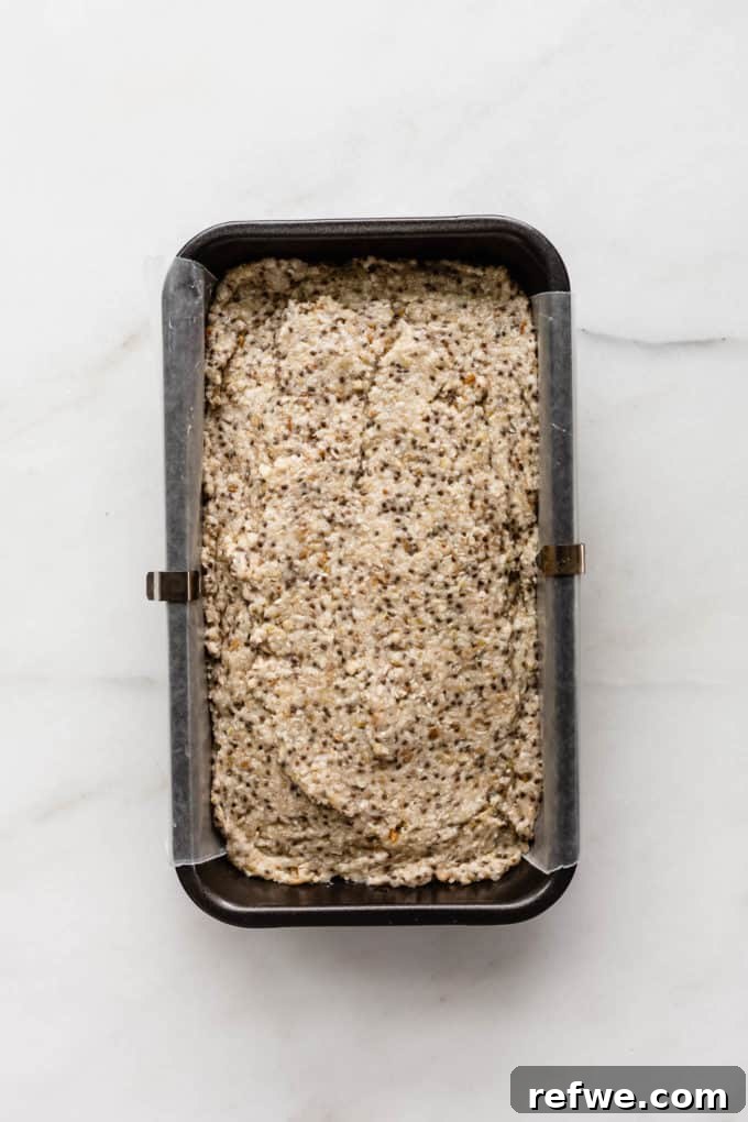 Wholesome Chia Buckwheat Loaf 7 Raw buckwheat chia bread batter uniformly spread in a parchment-lined loaf pan, ready for baking.