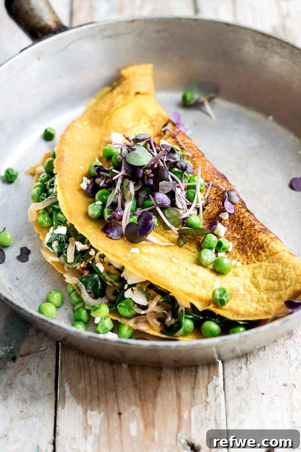 Vibrant Vegan & Gluten-Free Chickpea Omelette with Spinach and Spring Peas 4 A perfectly cooked vegan omelette filled with bright green spring peas and spinach, ready to be enjoyed as a wholesome and healthy breakfast.