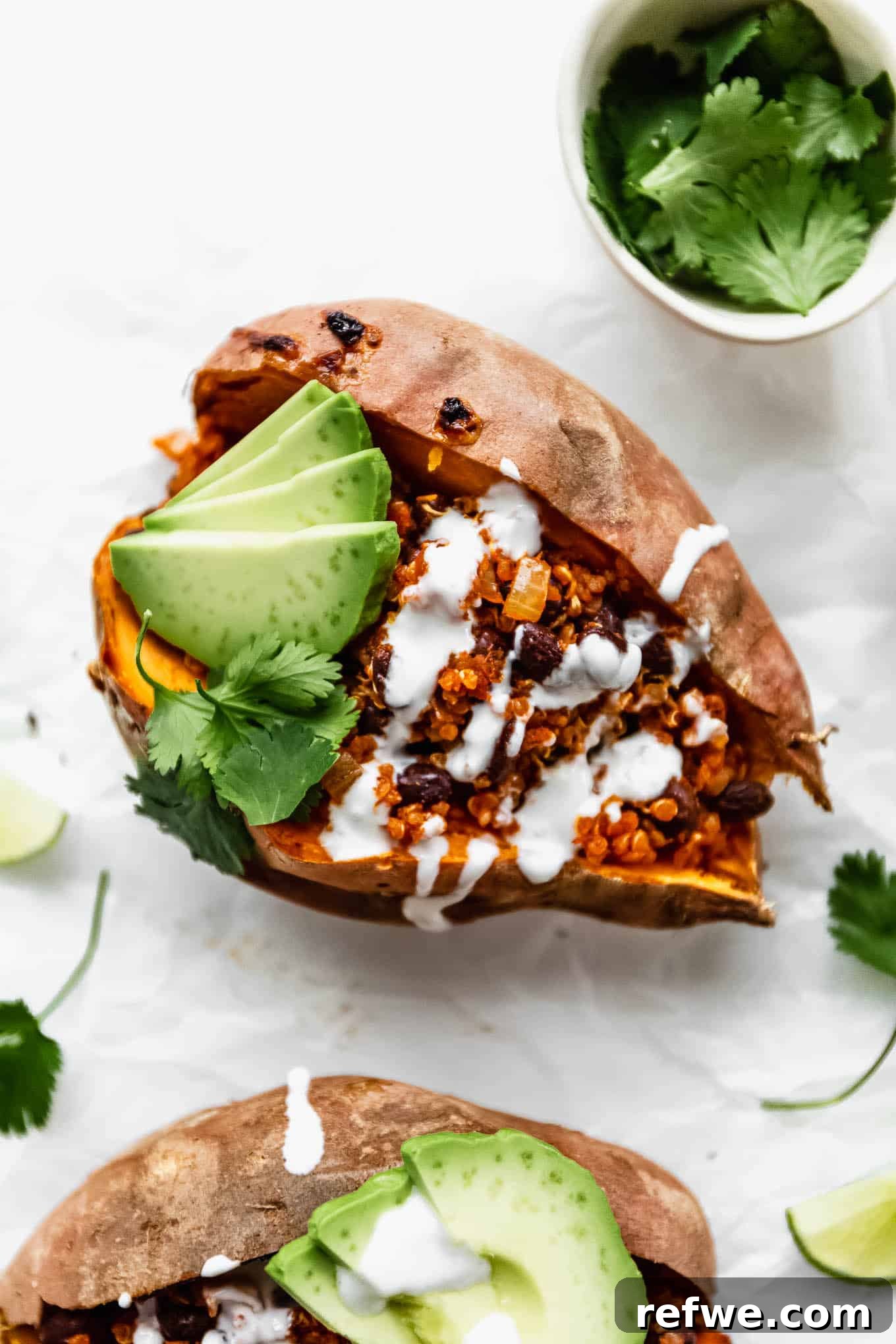 Hearty Black Bean Quinoa Stuffed Sweet Potatoes 2 A black bean and quinoa stuffed sweet potato generously topped with creamy sour cream and fresh avocado slices, ready to be enjoyed.