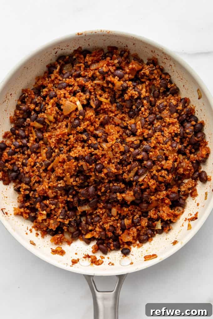 Hearty Black Bean Quinoa Stuffed Sweet Potatoes 8 The completed chipotle quinoa and black bean filling, perfectly seasoned and ready for stuffing, in a white pan.
