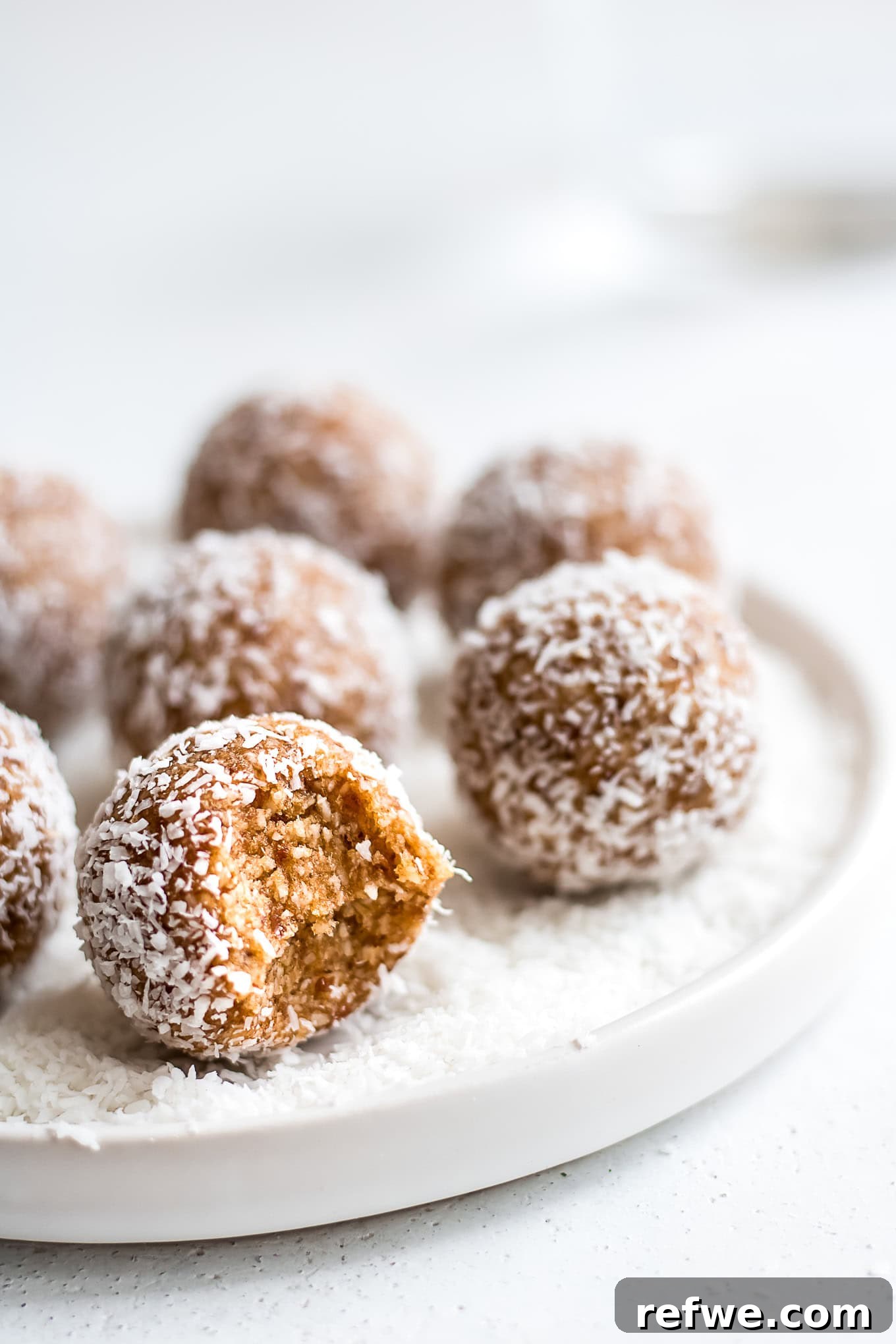 Irresistible Salted Caramel Coconut Bites 6 An inviting plate showcasing several salted caramel coconut bliss balls, artfully arranged, promising a delightful and healthy snack experience.