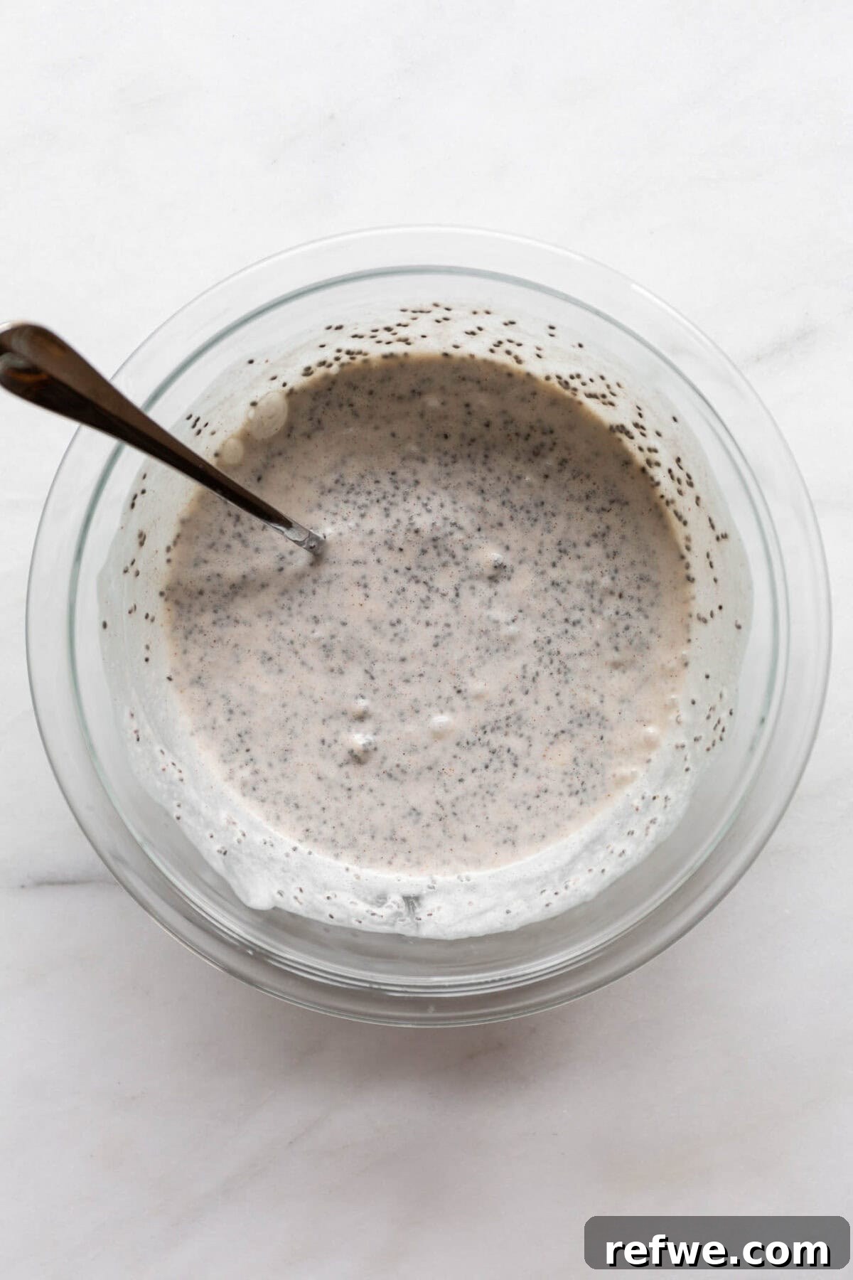 Wholesome Banana Chia Delight 6 The banana chia pudding mixture in a mixing bowl after initial stirring, showing a slightly liquid consistency before chilling.