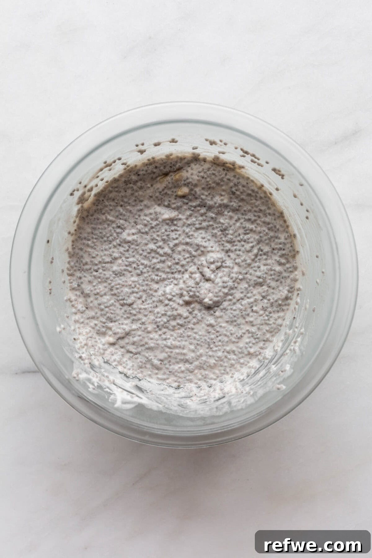 Wholesome Banana Chia Delight 7 A clear mixing bowl filled with thick, creamy, and fully set banana chia pudding, ready for serving.