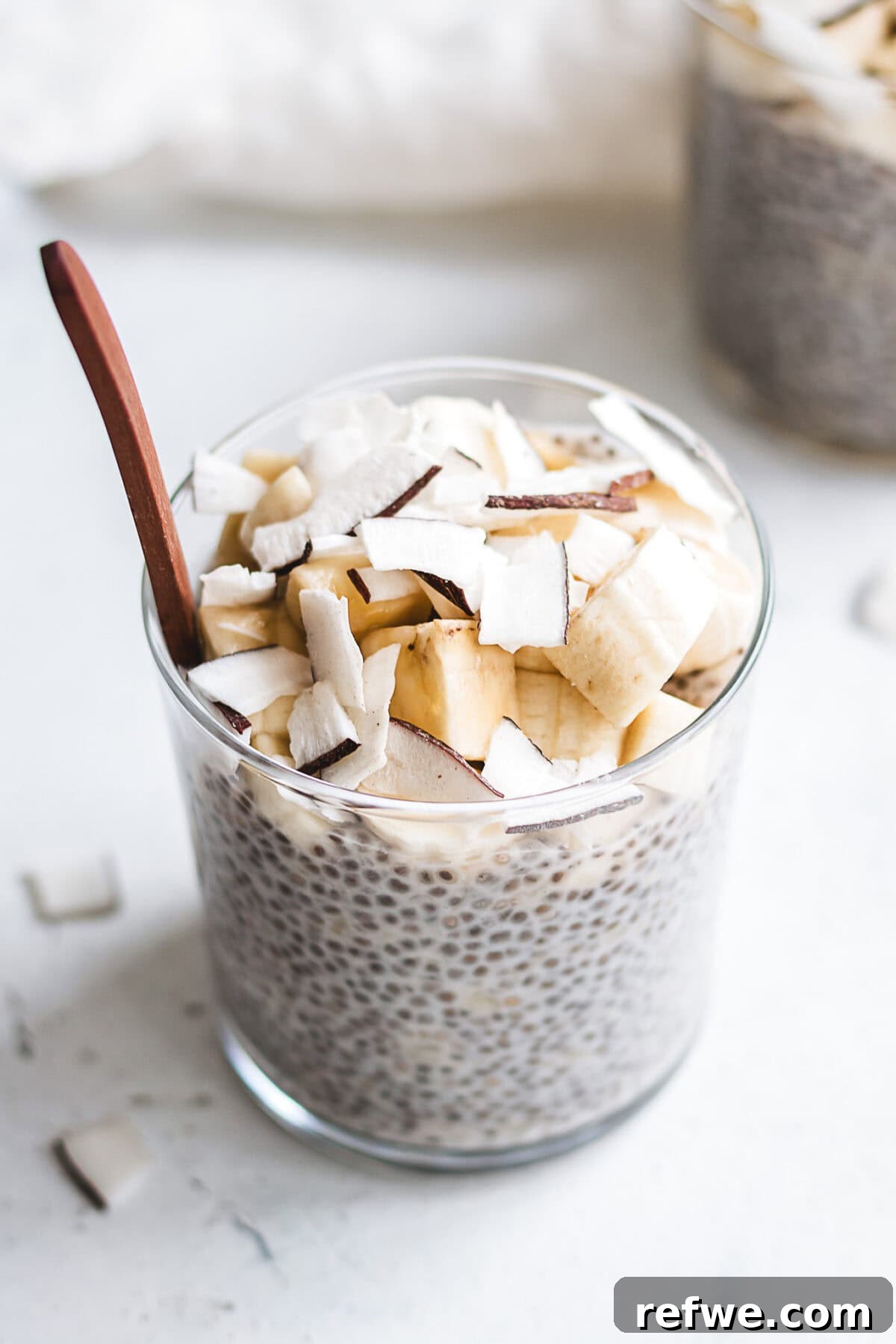 Wholesome Banana Chia Delight 8 A single serving cup of banana chia pudding, beautifully topped with fresh banana slices and a light sprinkle of cinnamon.