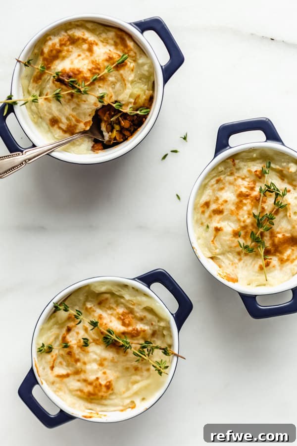Plant-Powered Lentil Shepherd's Pie 6 Several mini vegan lentil shepherd's pies baked to a golden perfection in small blue ramekins