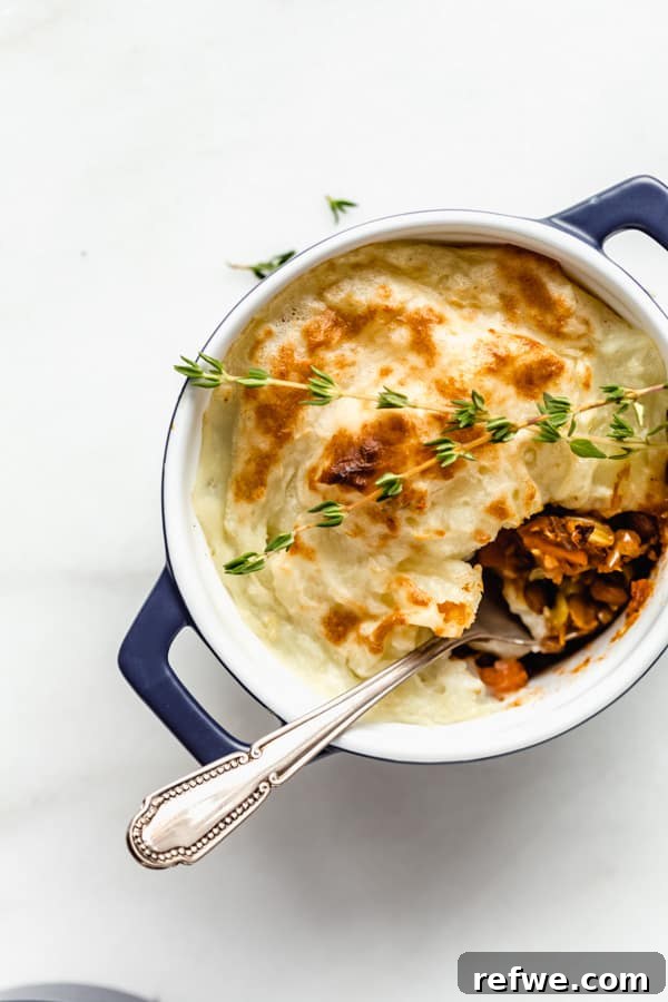 Plant-Powered Lentil Shepherd's Pie 7 A spoon scooping a delicious spoonful of the savory lentil mixture from a mini vegan lentil shepherd's pie