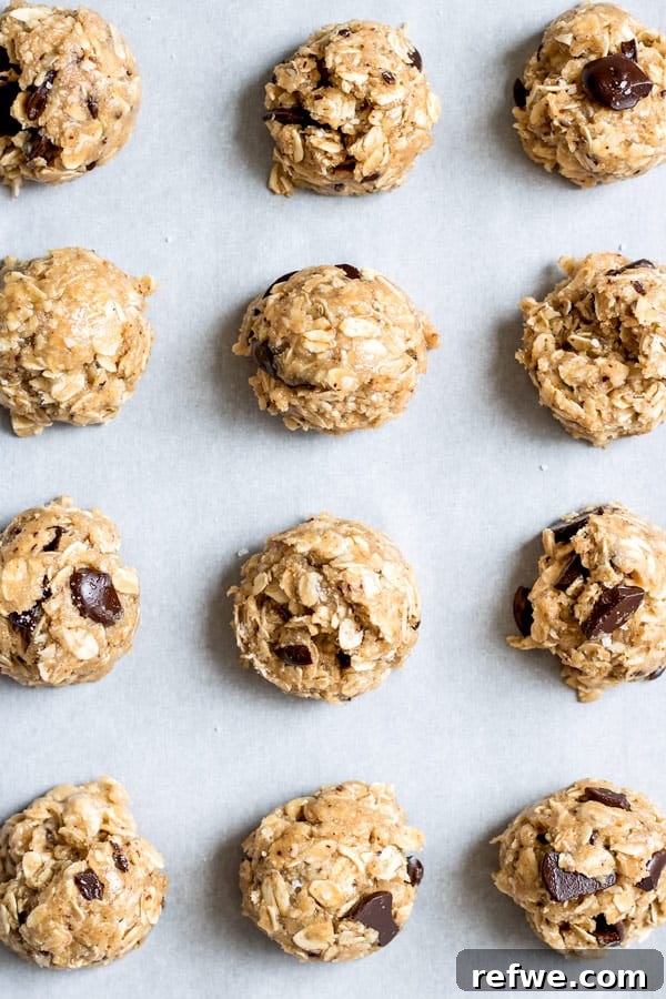 Close-up of freshly baked Chocolate Chunk Tahini Oatmeal Cookies on a cooling rack, highlighting the texture.
