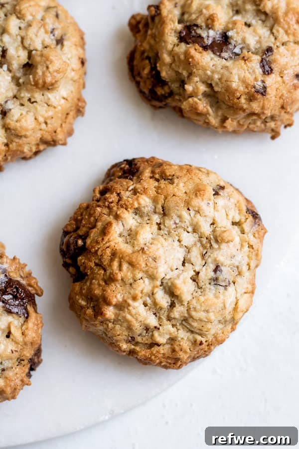 Four Chocolate Chunk Tahini Oatmeal Cookies stacked, showing their thick, chewy texture.