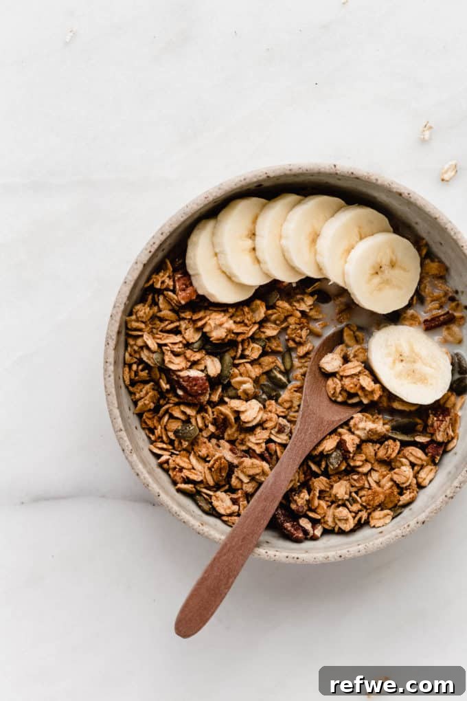 Cozy Autumn Granola 7 A bowl of delectable pumpkin spice granola generously topped with fresh banana slices.