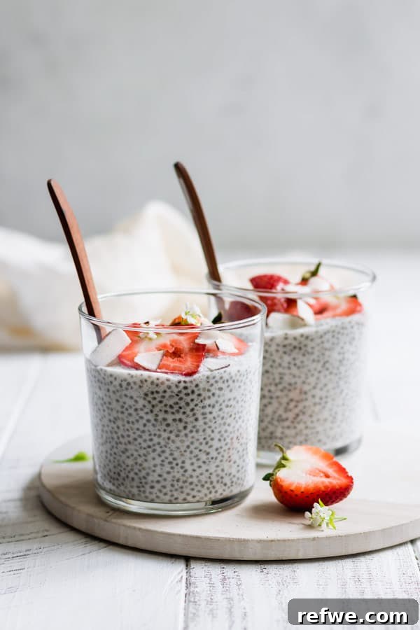 Two aesthetically arranged cups of coconut chia pudding on a round white marble tray, ready to be enjoyed.