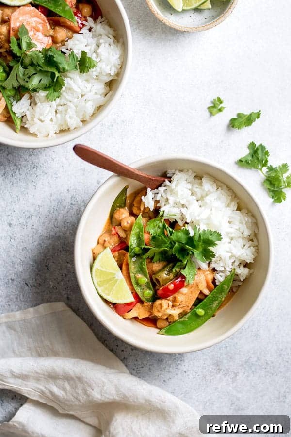 Vibrant vegetarian Thai red curry with colorful vegetables and chickpeas, served in a bowl.