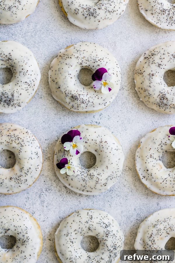 Close-up of baked vegan lemon poppy seed donuts on a cooling rack