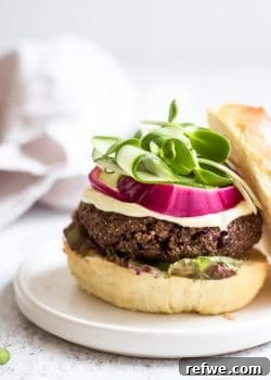 Black bean quinoa burgers stacked on a bun with fresh toppings.
