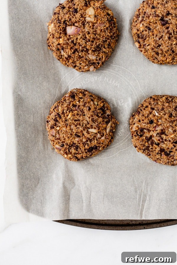 Southwest Quinoa Black Bean Burgers 7 Uncooked black bean and quinoa burger patties neatly arranged on a baking pan with parchment paper.
