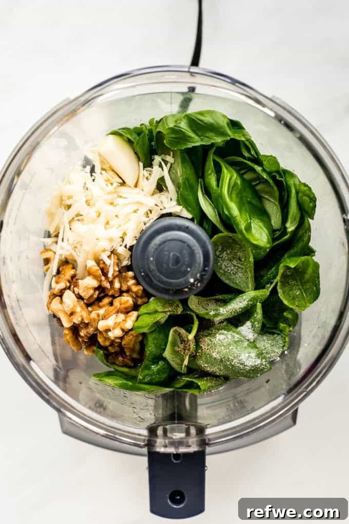 Zesty Pesto Veggie Medley 3 Fresh basil, walnuts, garlic, and Parmesan cheese gathered in a food processor bowl, ready to be blended