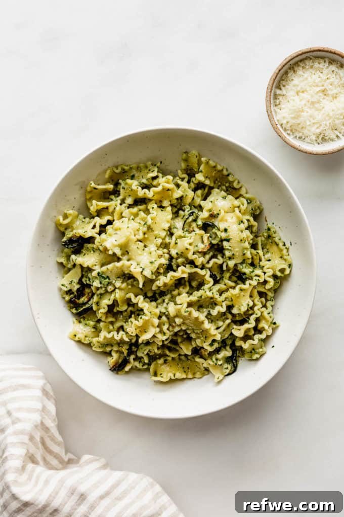 Zesty Pesto Veggie Medley 9 A bowl of veggie pesto pasta artfully arranged with a small bowl of grated Parmesan cheese on the side