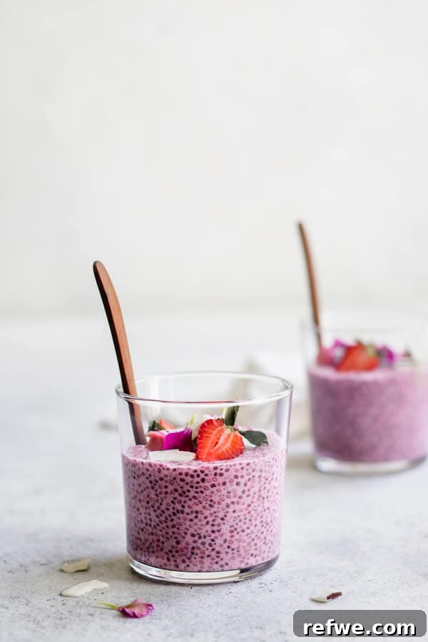 Overhead shot of two glasses of Strawberry Dragonfruit Chia Pudding garnished with fresh fruit.