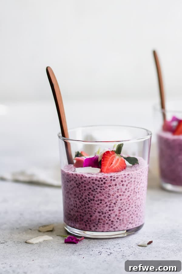 Stylized flat lay of Strawberry Dragonfruit Chia Pudding in a glass jar, surrounded by fresh fruit and ingredients.