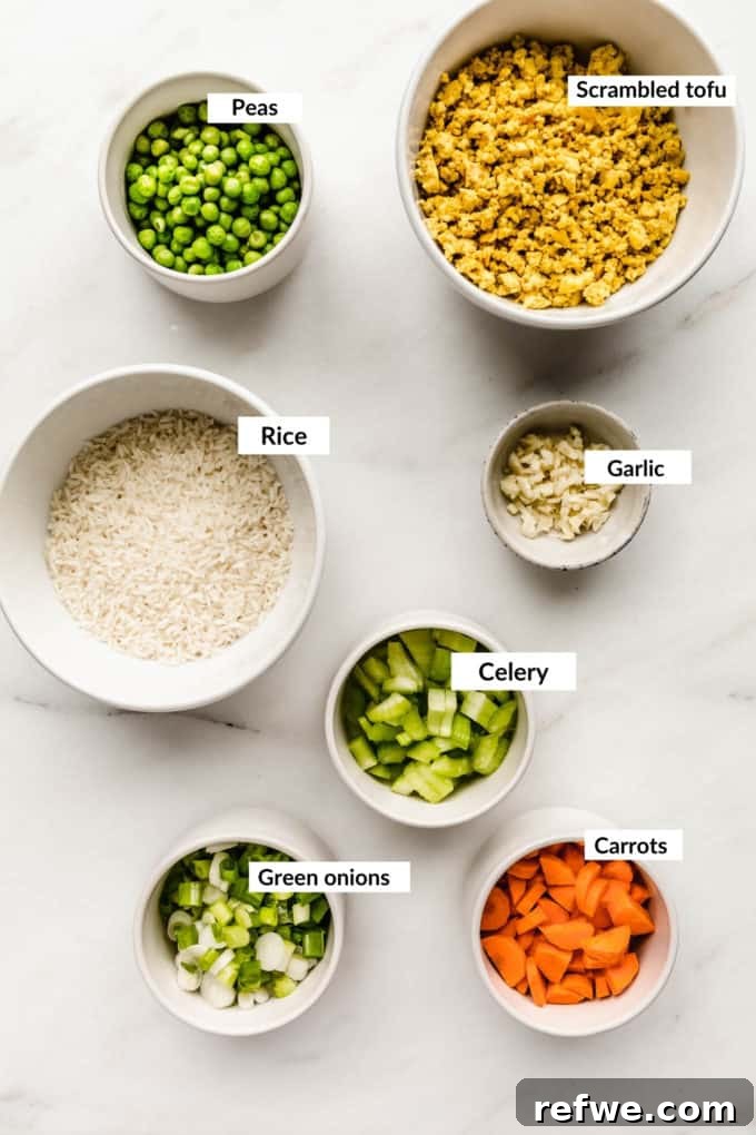 Savory Vegan Tofu Fried Rice 3 A vibrant flat lay of fresh ingredients laid out for vegan fried rice, showcasing colorful vegetables and tofu.