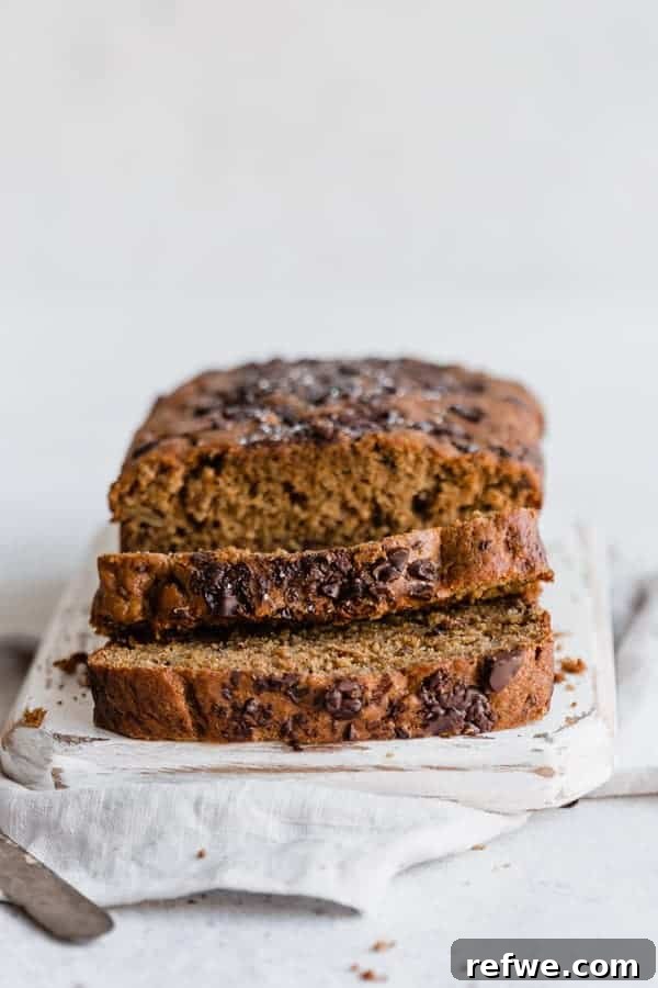 Rustic Rye Banana Bread with Dark Chocolate Chunks 2 dark chocolate chip & rye banana bread sliced on a cutting board, showcasing its rich texture and chocolate chunks