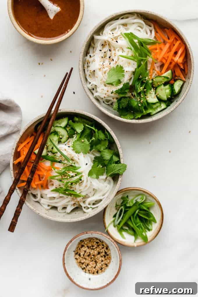 Spring Roll Power Bowls with Zesty Almond Butter Sauce 4 Two bowls of rice noodles and fresh vegetables with chopsticks, waiting for sauce.