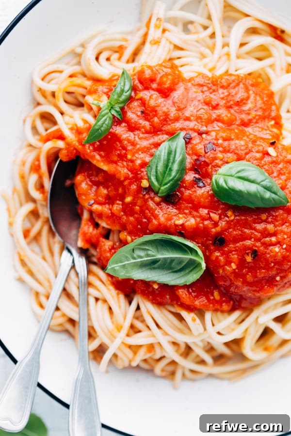 spaghetti with homemade tomato sauce garnished with fresh basil leaves