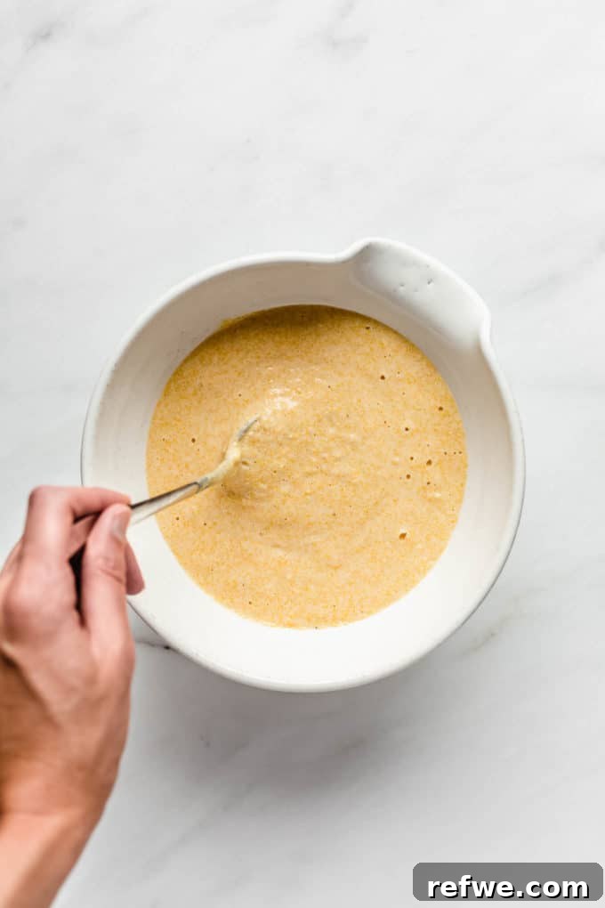 Plant-Based Cornbread 6 Creamy vegan cornbread batter mixed in a pristine white mixing bowl, showcasing its smooth yet slightly textured consistency.