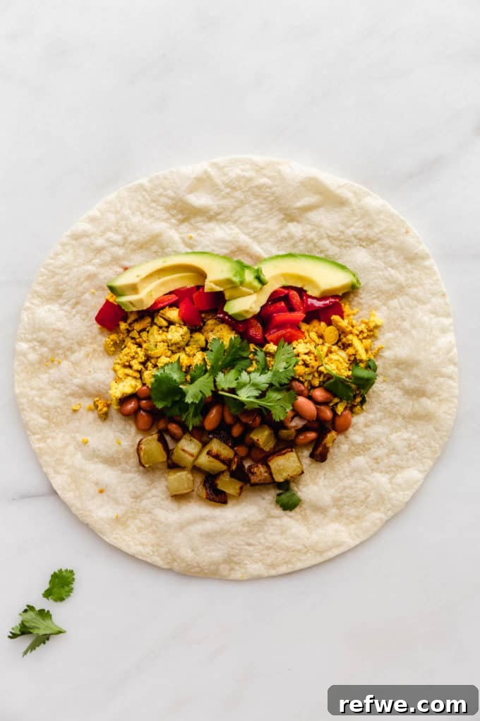 Plant-Powered Breakfast Wrap 4 A tortilla with avocado, scrambled tofu, and other vegetables laid out