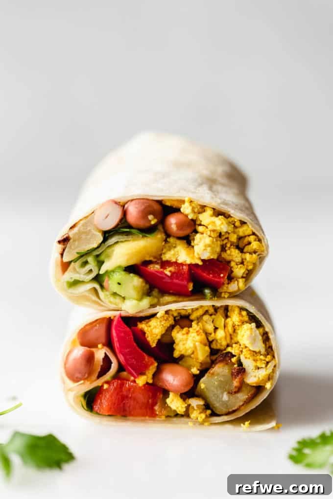 Plant-Powered Breakfast Wrap 7 Two vegan breakfast burritos stacked on top of each other, one cut in half