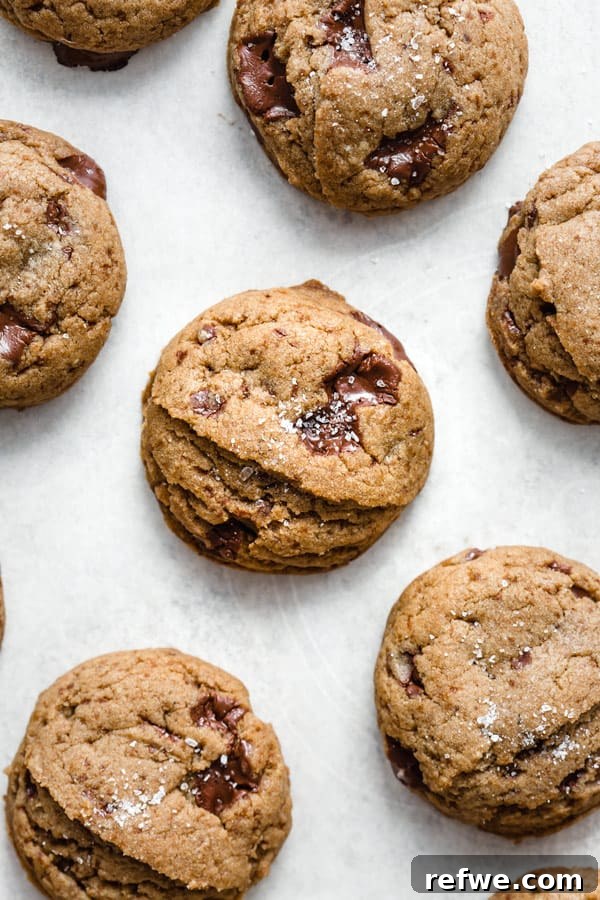 A hand holding a vegan spiced chocolate chunk cookie