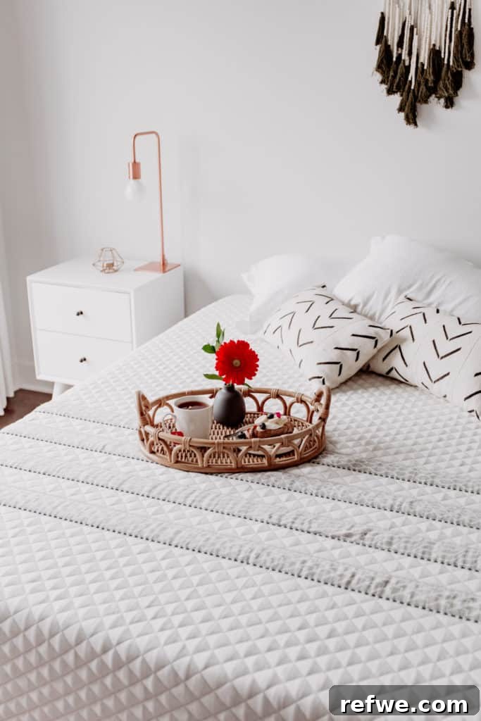Indulgent Mornings Breakfast in Bed Secrets 6 A beautifully arranged serving tray featuring a delicate flower, a cup of tea, and a croissant, all on a soft bed.