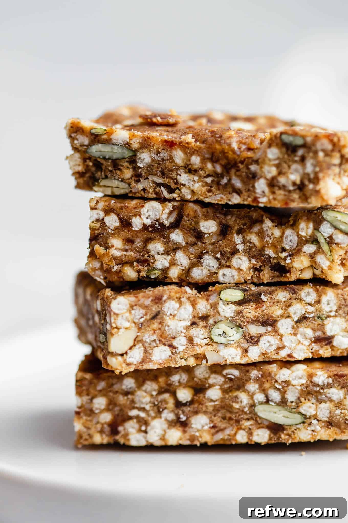 Crispy Quinoa Nut Bars 2 A stack of four homemade puffed quinoa and nut bars, showcasing their wholesome texture and appeal.