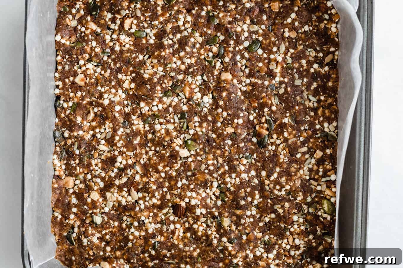 Crispy Quinoa Nut Bars 13 The quinoa date bar mixture firmly pressed into a pan lined with parchment paper, chilling in the fridge.