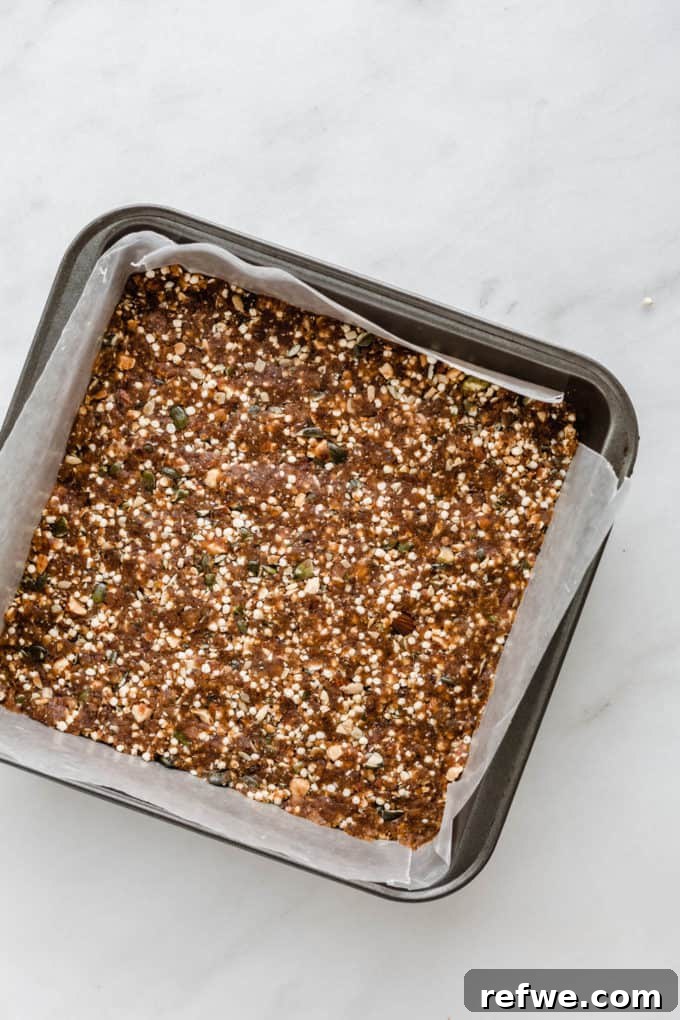 Crispy Quinoa Nut Bars 3 Freshly made puffed quinoa and nut bars cooling in a baking pan, ready to be sliced.