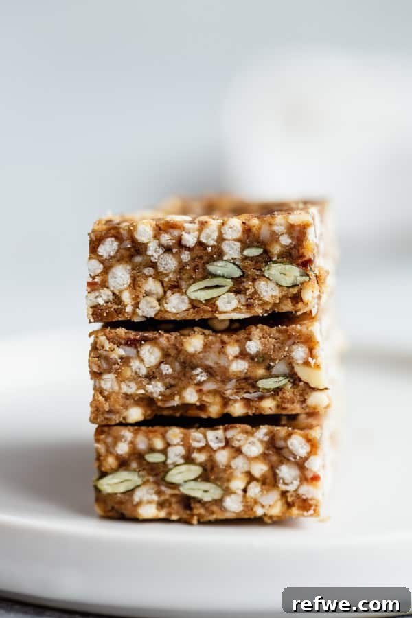Crispy Quinoa Nut Bars 5 Three puffed quinoa bars neatly stacked on a plate with a simple napkin, highlighting their wholesome goodness.