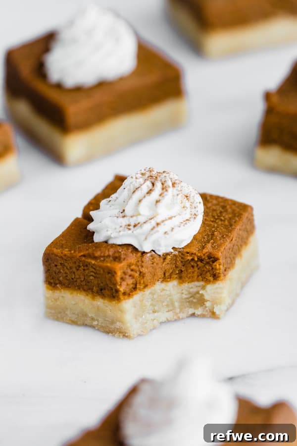 Autumn Spiced Pumpkin Bars with Almond Cookie Crust Vegan and Paleo 4 Several pumpkin pie bars on a wooden surface, ready to be served.