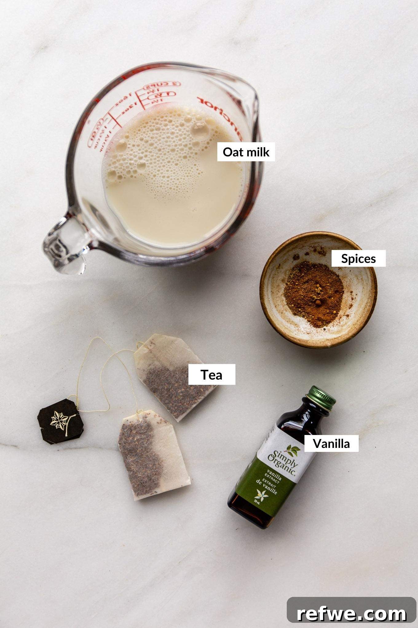 Homebrewed Chai Spice Bliss 3 A flat lay image displaying the key ingredients for a chai latte, including spices, tea bags, and oat milk.