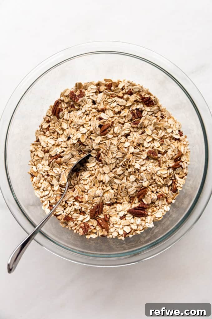 oats, puffed quinoa and pecans mixed together in a mixing bowl