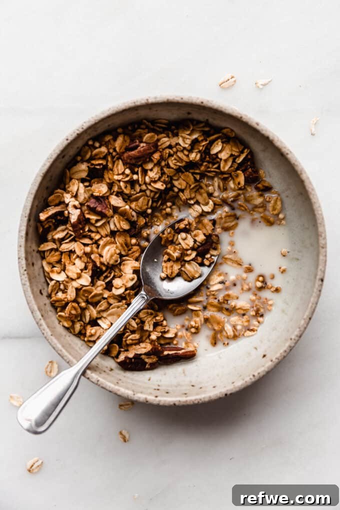 A bowl of maple pecan granola with almond milk and fresh fruit