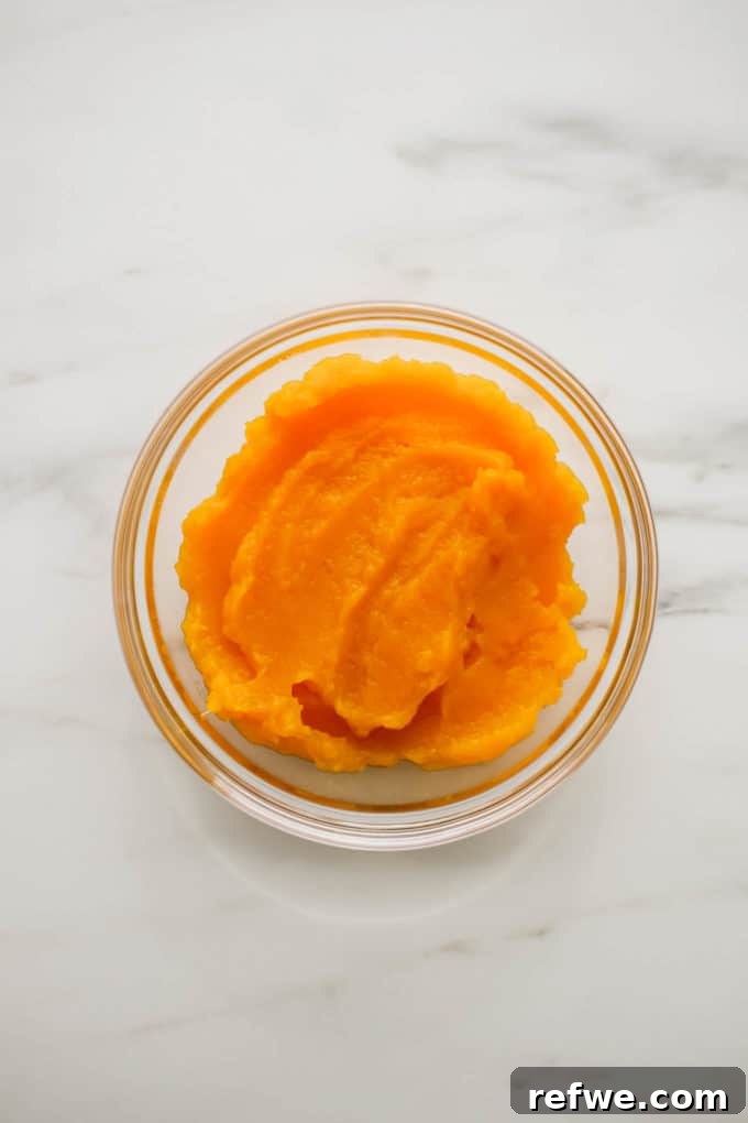 Silky smooth butternut squash puree in a blender, a vibrant orange color.