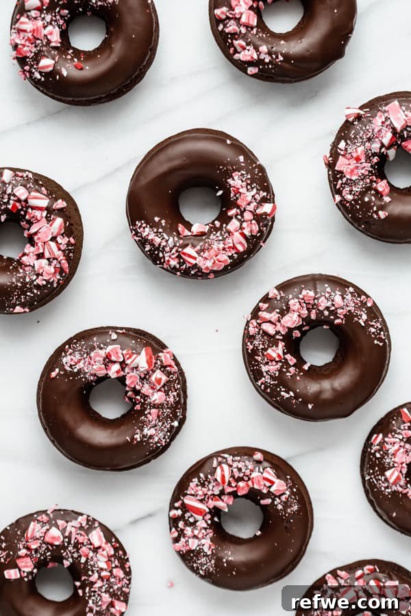 Peppermint Mocha Vegan Dream Rings 4 Beautifully arranged vegan peppermint mocha donuts on a marble board, garnished with an abundance of crushed candy canes.