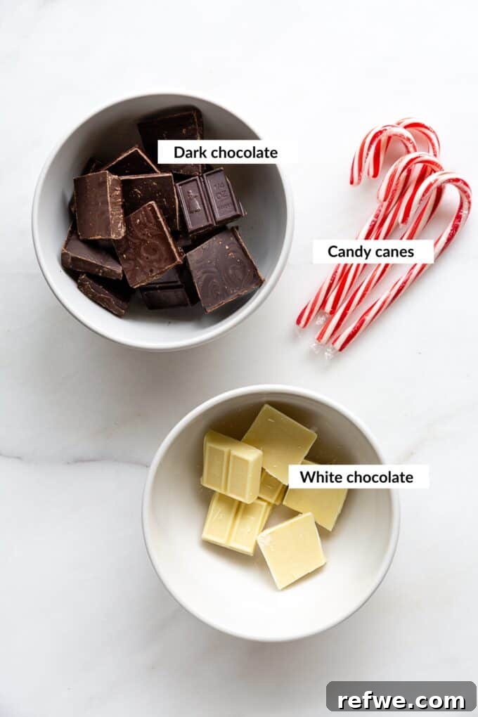Wintermint Swirl Bark 3 Essential ingredients for homemade peppermint bark including dark chocolate, white chocolate, and crushed candy canes laid out on a clean surface.