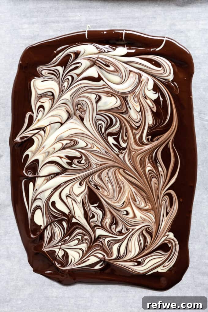 Wintermint Swirl Bark 8 Beautifully swirled dark and white chocolate on a baking sheet, showcasing the marbled effect before adding toppings.
