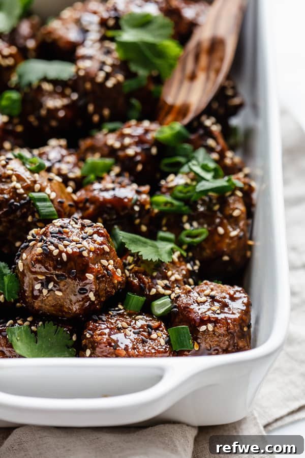 Tangy Glazed Vegan Meatballs 5 Hand picking up a plant-based sweet and sour meatball with a toothpick