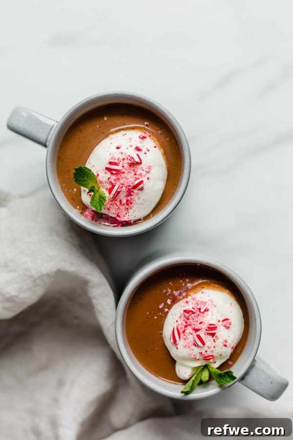 Velvety Vegan Peppermint Hot Cocoa 3 Close-up of a mug of vegan peppermint hot chocolate with a subtle swirl of cream, highlighting its rich texture and color.