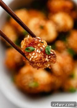 A piece of panko-crusted cauliflower coated in sweet and spicy Bang Bang sauce.
