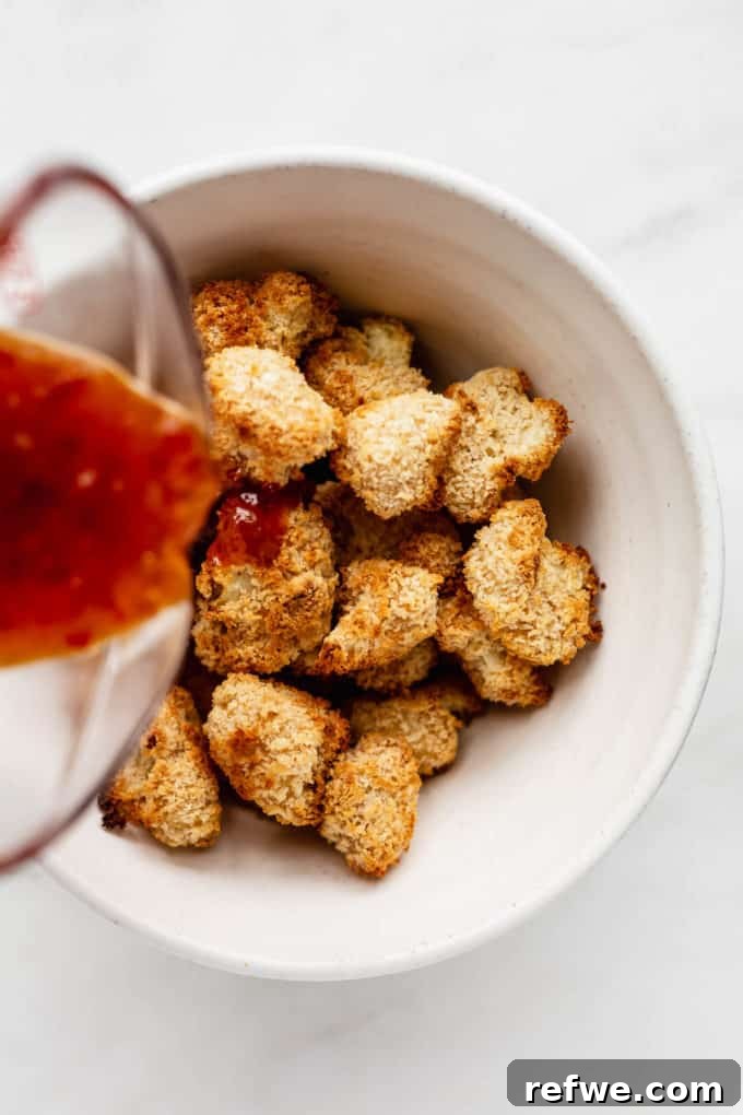 Dynamite Cauliflower 7 Sweet and spicy bang bang sauce being poured over a bowl of crispy panko-crusted cauliflower
