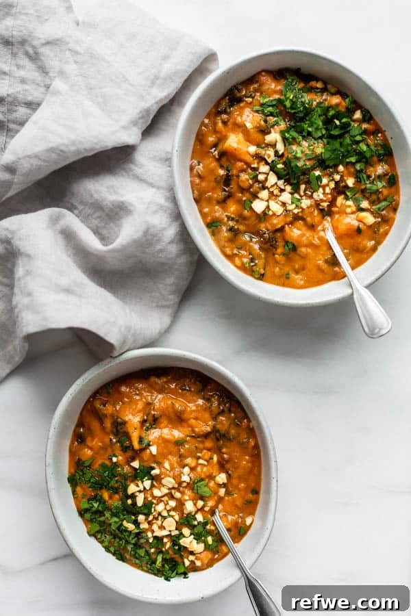 Cozy Vegan Peanut Pot 5 Two bowls of West African peanut stew, accompanied by a soft grey napkin, creating a delightful and inviting presentation.