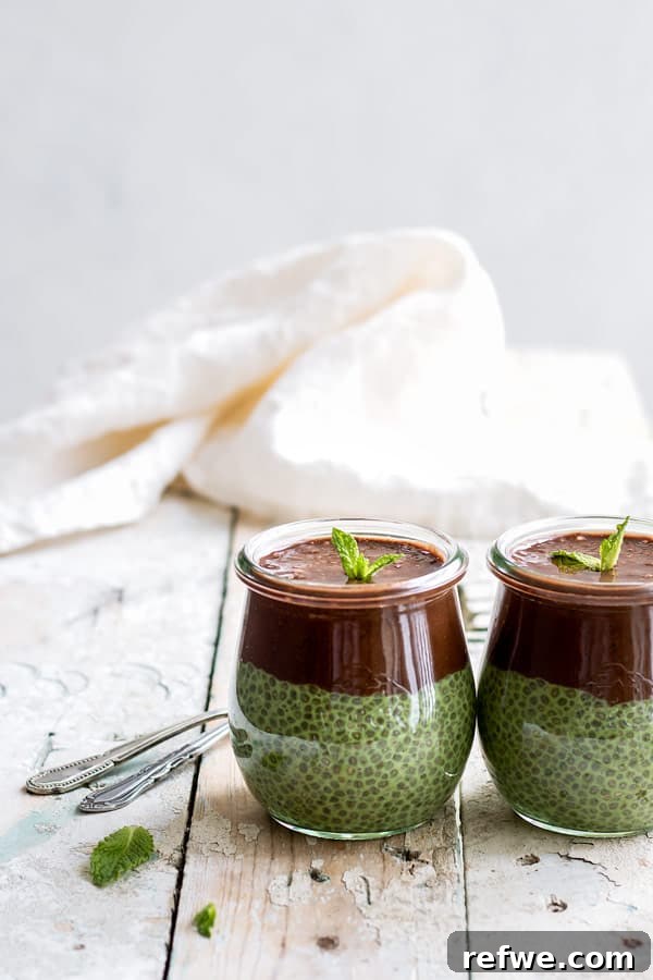 Refreshing Mint Chocolate Matcha Chia Pudding 3 Two small jars of green mint chia pudding topped with a rich chocolate layer, ready to be enjoyed.