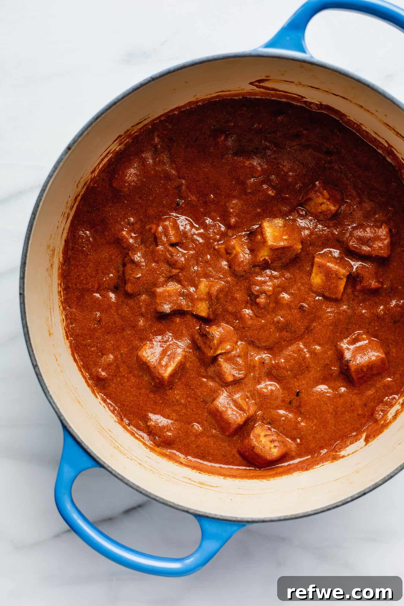 Spiced Tofu Tikka Masala Feast 3 Close-up of Tofu Tikka Masala in a pan, showcasing the rich, orange sauce and tender tofu pieces.